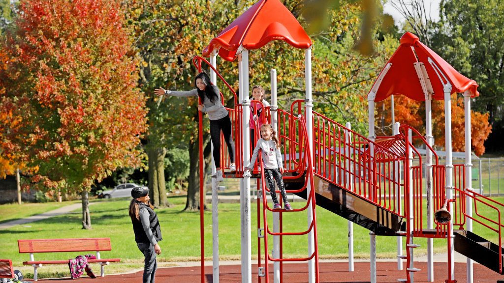 girls playing on the slides in the park
