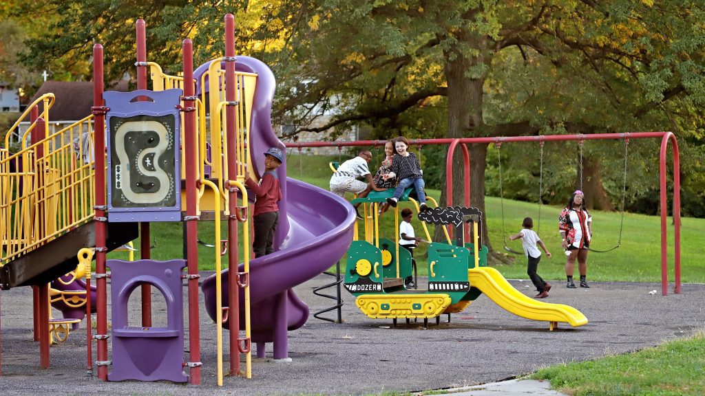 kids playing on the slides and swings in the park